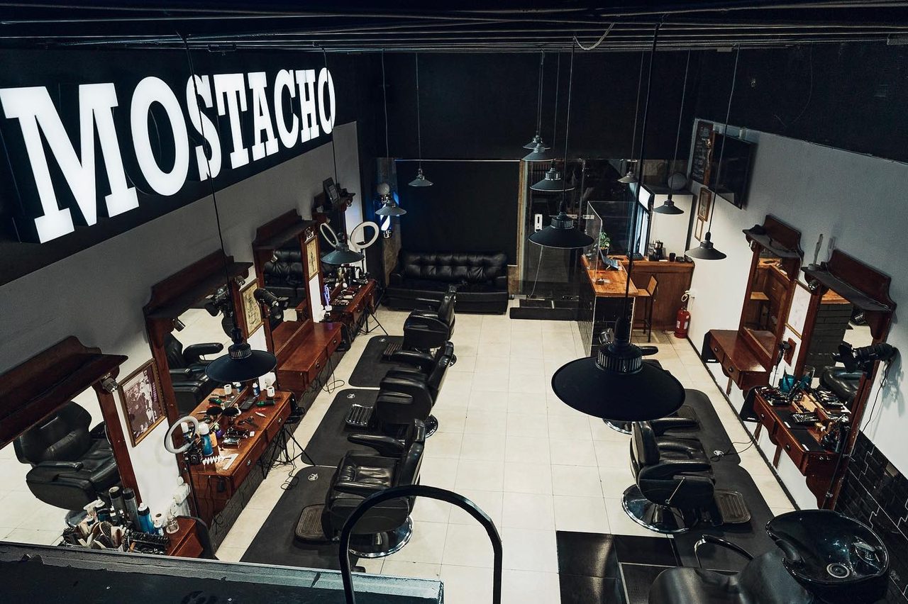 Salón de Barbería Mostacho con el letrero y las estaciones de trabajo